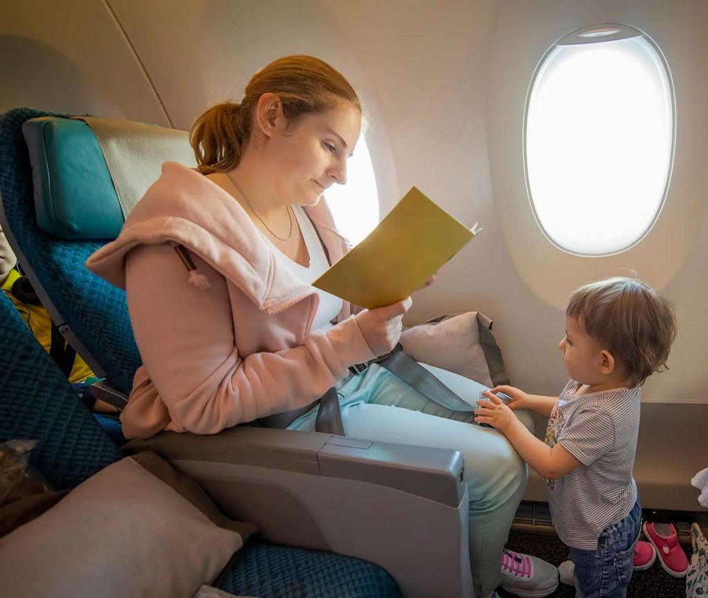 Mother reads medicines information on an aircraft.