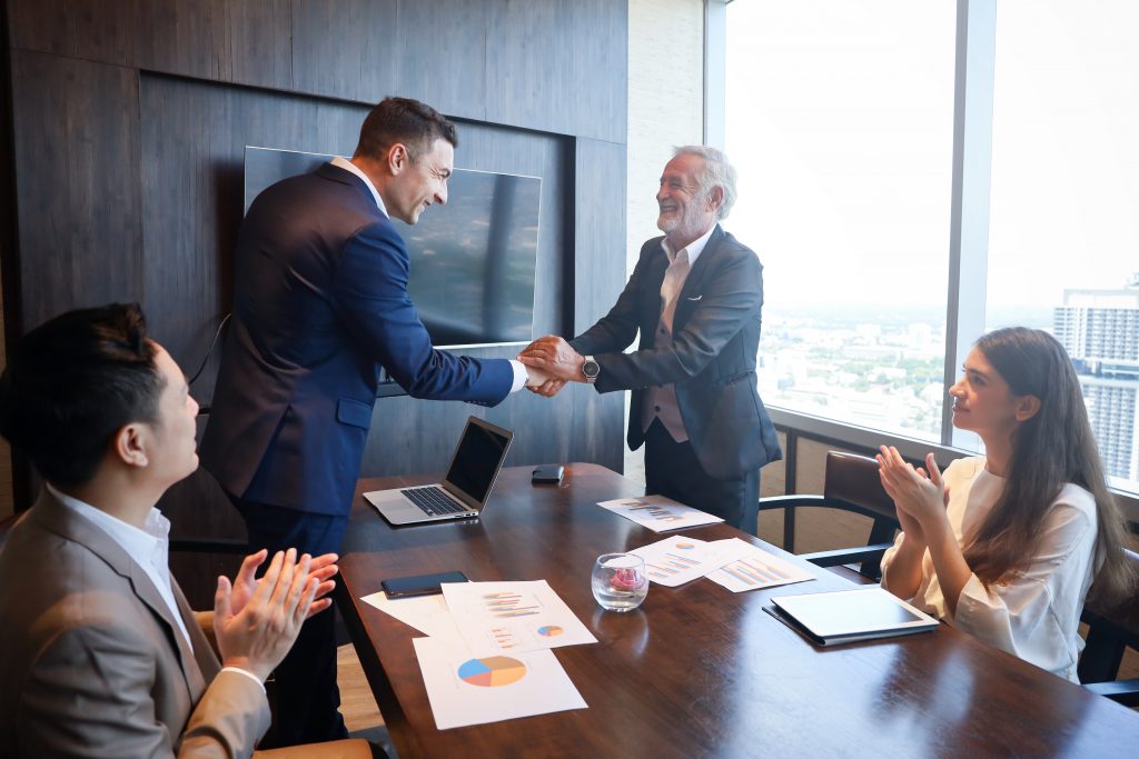 Lay language communications: business team celebrate a successful deal.