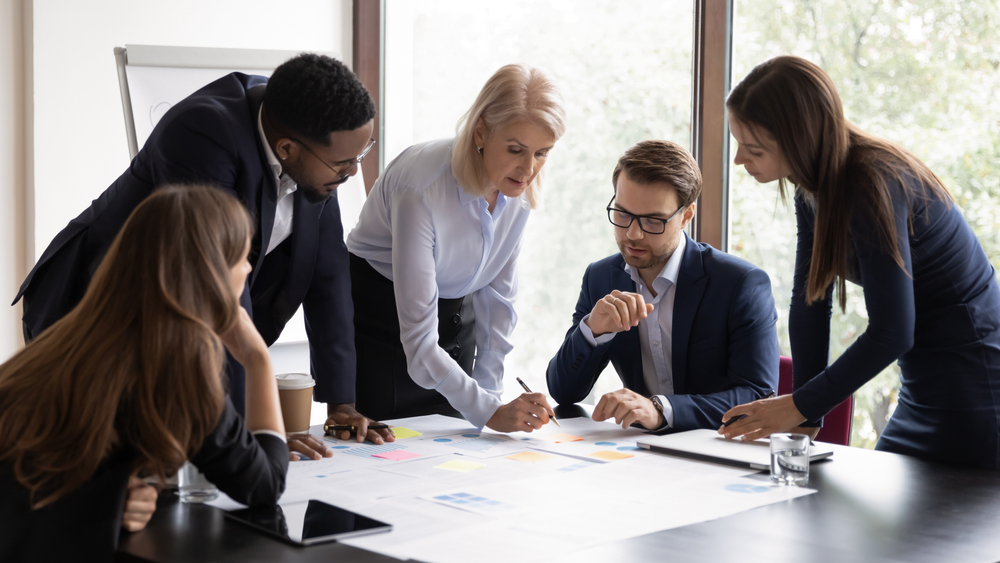 Lay language communications: group of business people working together on a document.