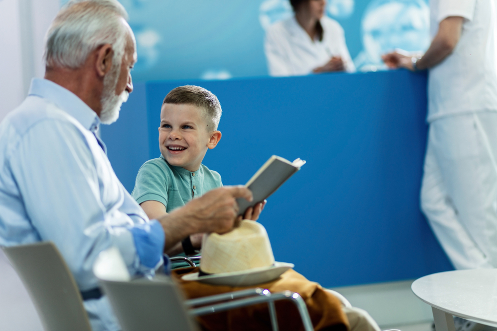 Lay language communications: grandfather and small boy wait in a clinic room