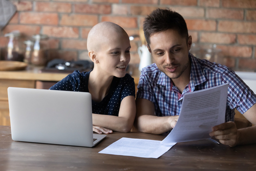 Cancer patient at home reading medical informatin with family memberadults - teen with cancer reads medical information with family member